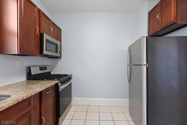 a kitchen with stainless steel appliances granite countertop a refrigerator a stove a sink and dishwasher