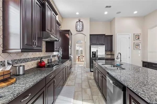 a kitchen with stainless steel appliances granite countertop a sink a stove and a refrigerator