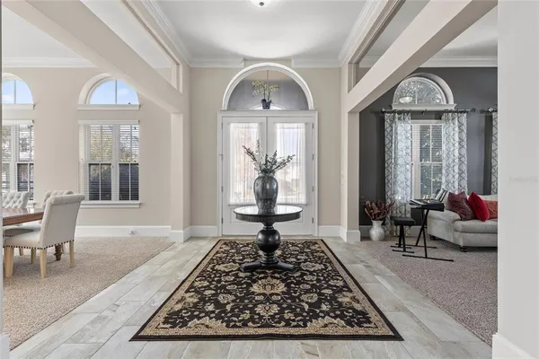 a living room with patio furniture and a chandelier