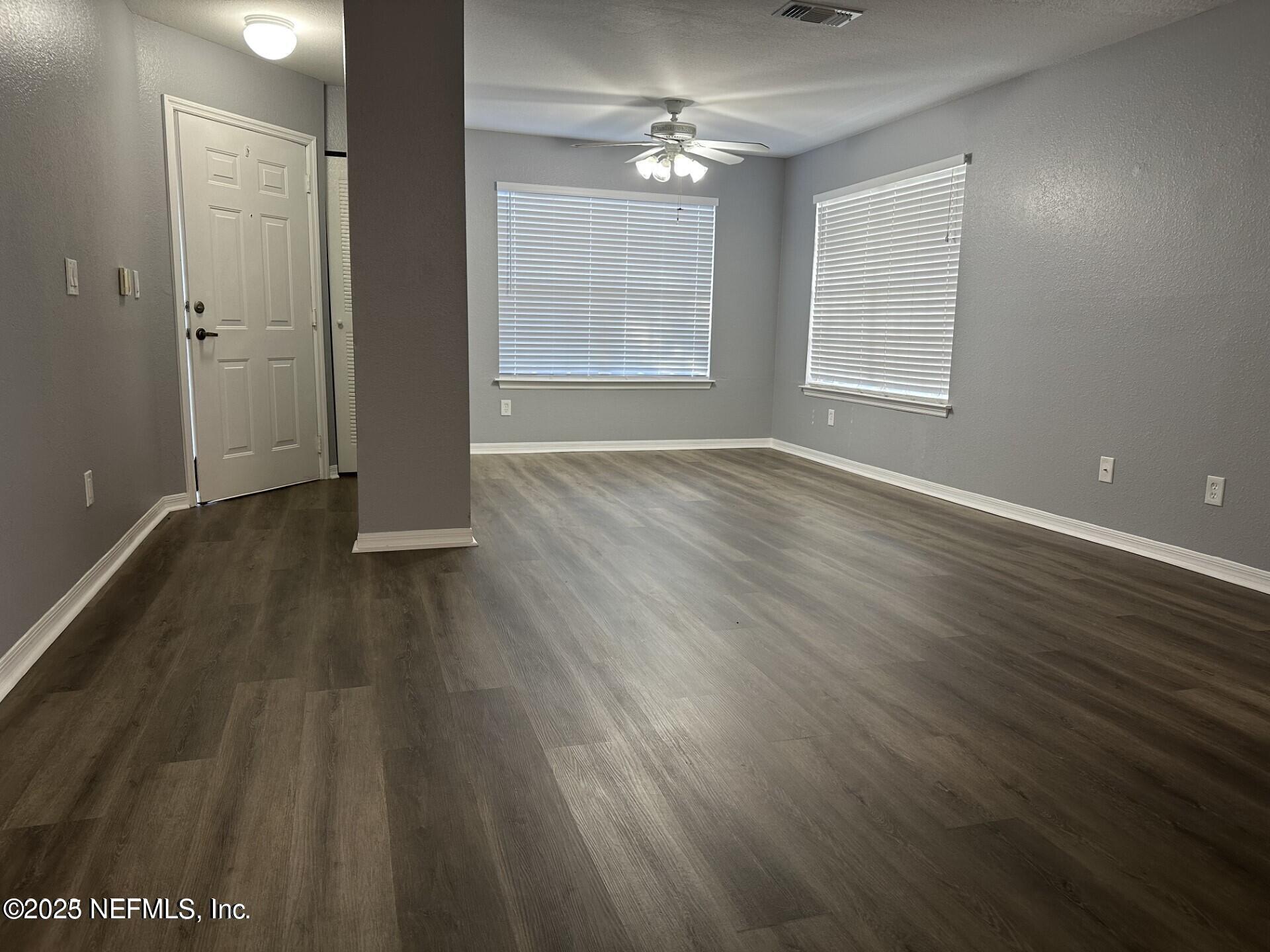 1717 County Road 220, Unit 2102 Fleming Island, FL 32003 - Photo 3 of 10 an empty room with wooden floor and windows