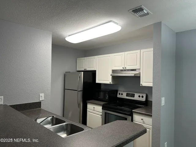 an empty room with wooden floor fan and window