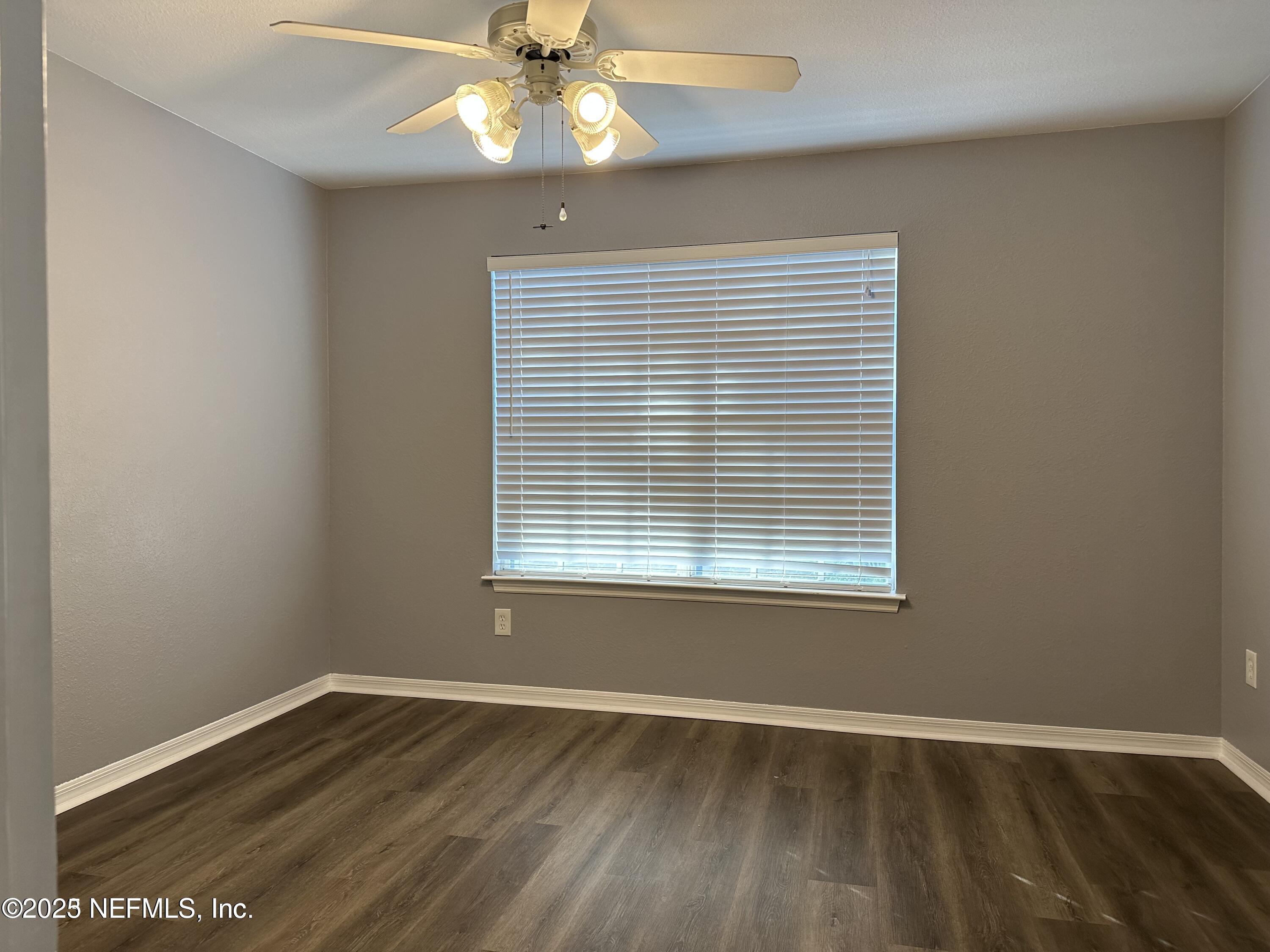1717 County Road 220, Unit 2102 Fleming Island, FL 32003 - Photo 6 of 10 an empty room with wooden floor fan and window