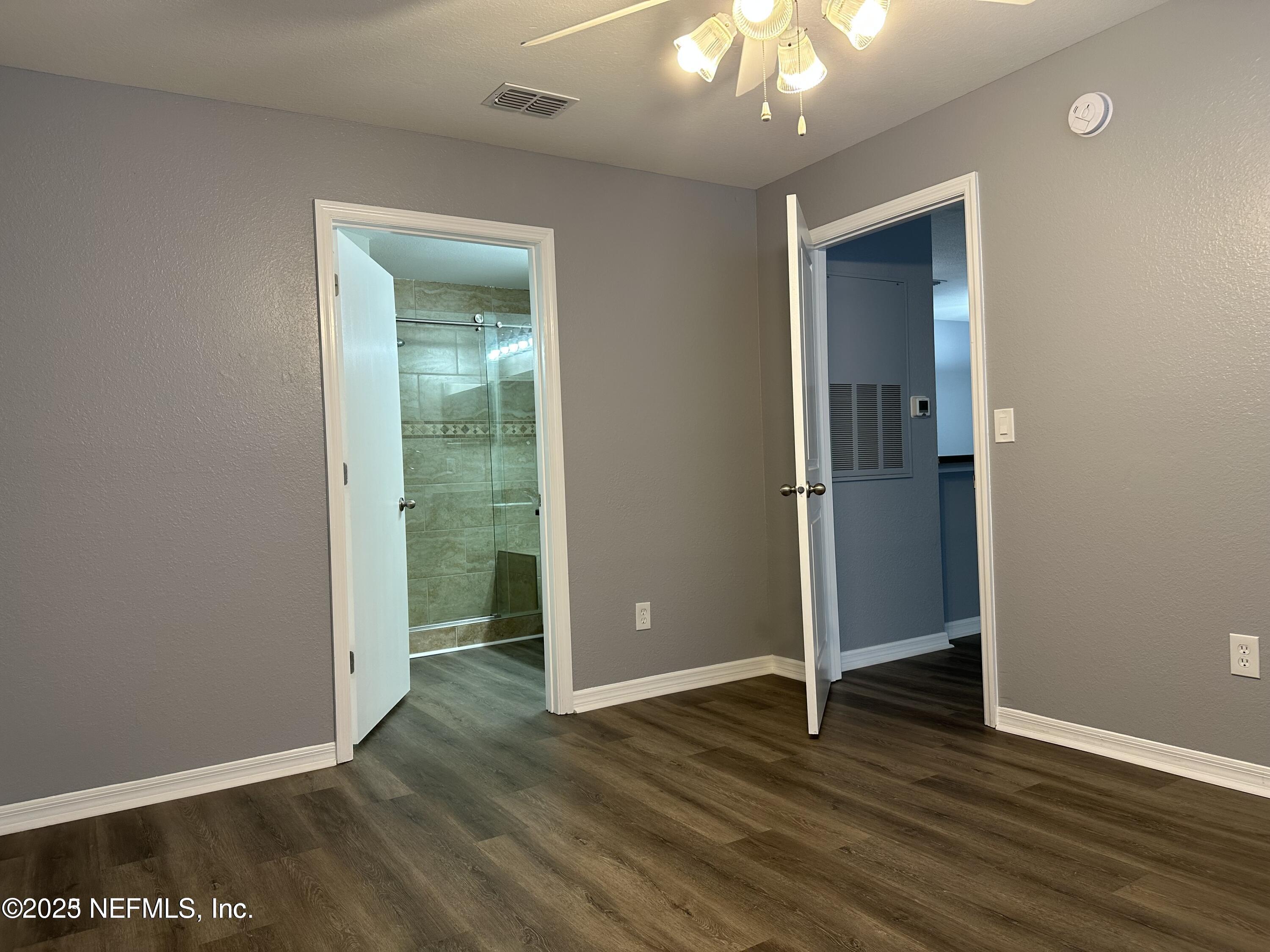 1717 County Road 220, Unit 2102 Fleming Island, FL 32003 - Photo 7 of 10 an empty room with wooden floor and way to kitchen