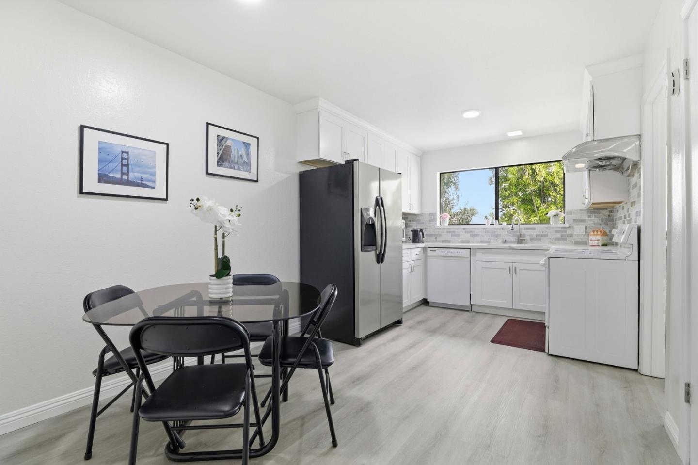 4013 Ralston Common Fremont, CA 94538 - Photo 14 of 40 a kitchen with a table chairs refrigerator and microwave