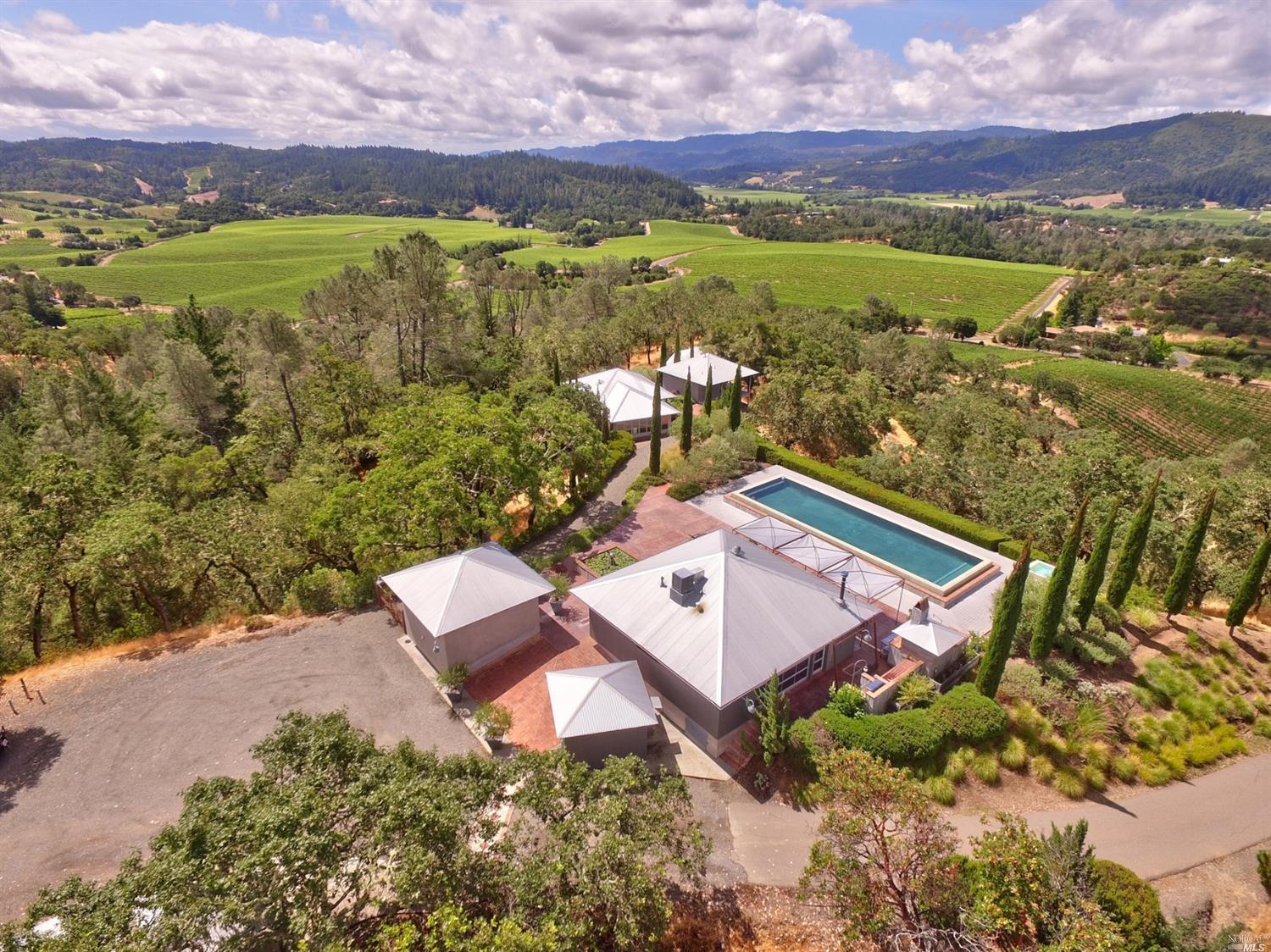 an aerial view of residential houses with outdoor space and ocean