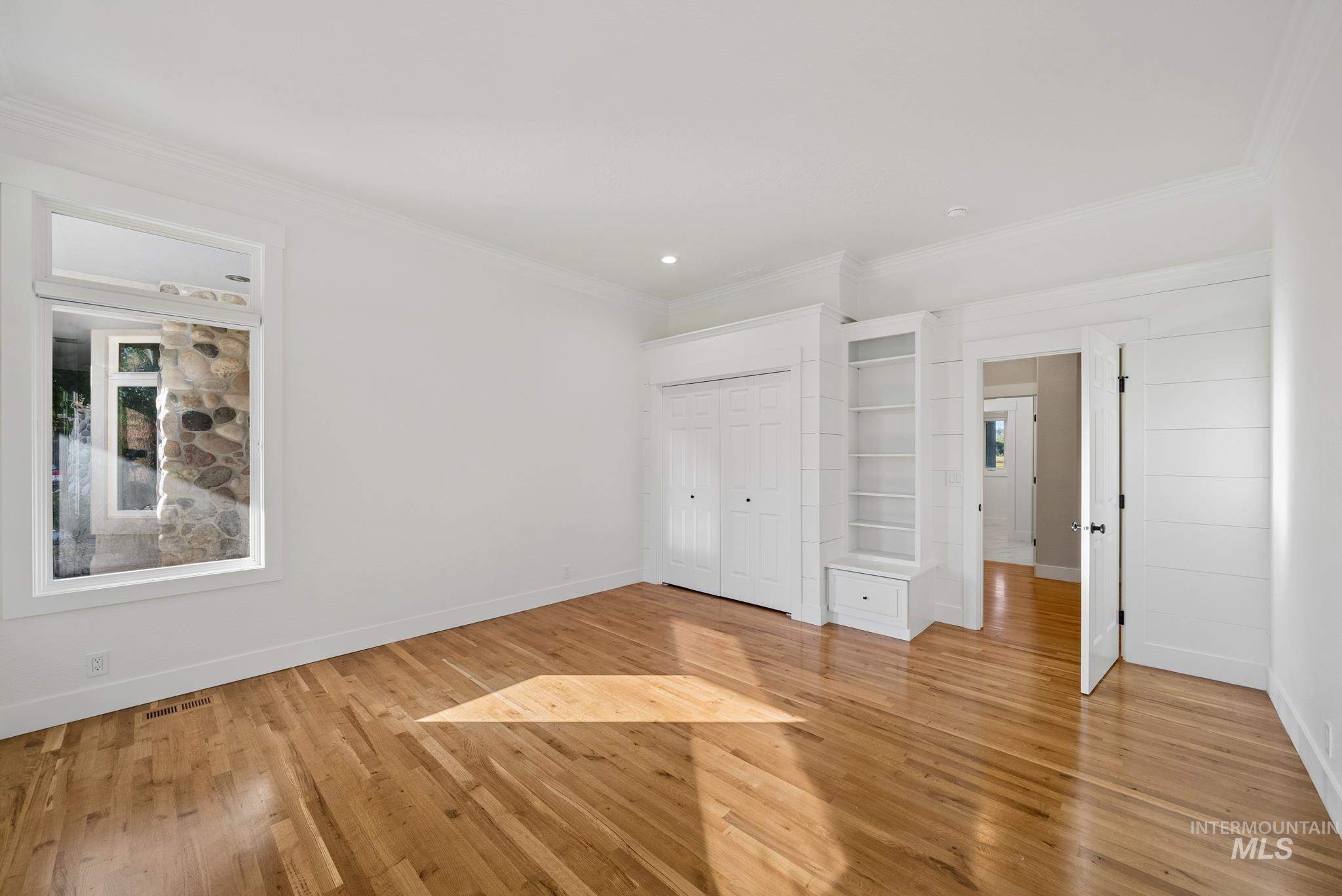 2050 Artesian Road Eagle, ID 83616 - Photo 36 of 49 Bright room featuring multiple windows, wood-finish flooring, white walls, and crown molding