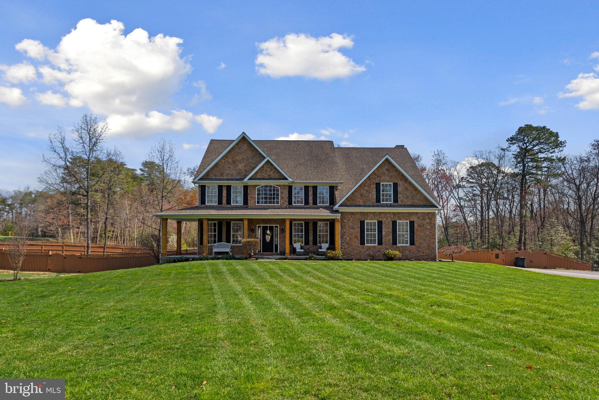 a view of a house with a big yard and large trees