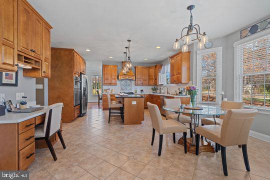 784 Olivia Way Pasadena, MD 21122 - Photo 11 of 38 a dining room with stainless steel appliances kitchen island granite countertop a dining table chairs and a refrigerator