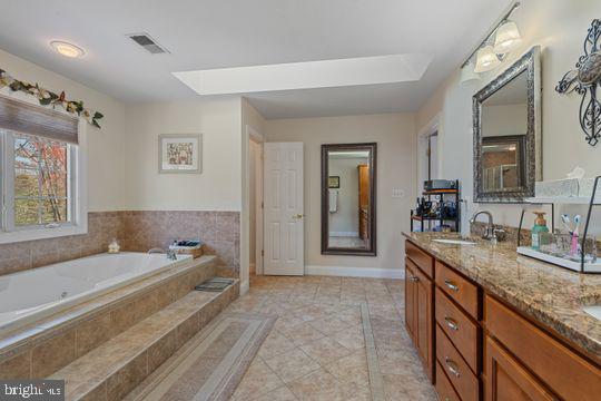 784 Olivia Way Pasadena, MD 21122 - Photo 22 of 38 a spacious bathroom with a granite countertop sink and a bathtub