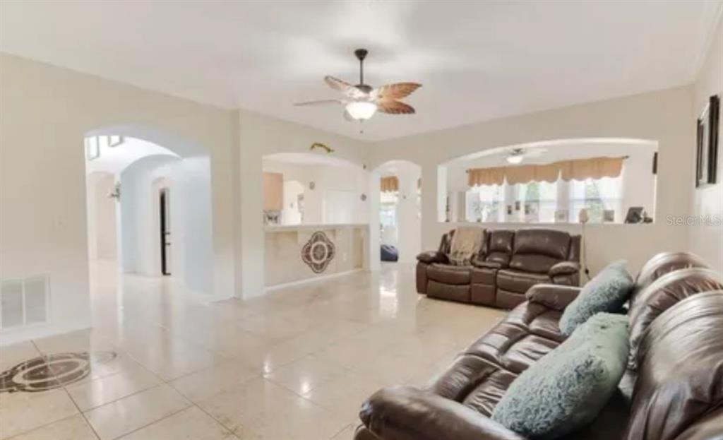 13315 Daffodil Way Astatula, FL 34705 - Photo 12 of 29 a living room with furniture a large window and a chandelier