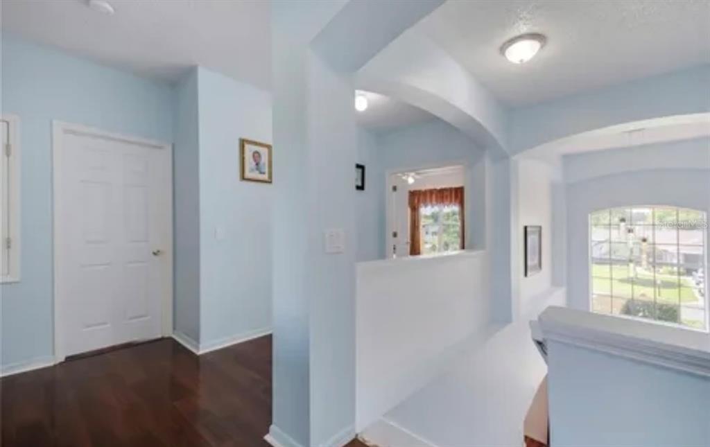 13315 Daffodil Way Astatula, FL 34705 - Photo 16 of 29 a hallway with windows and chandelier