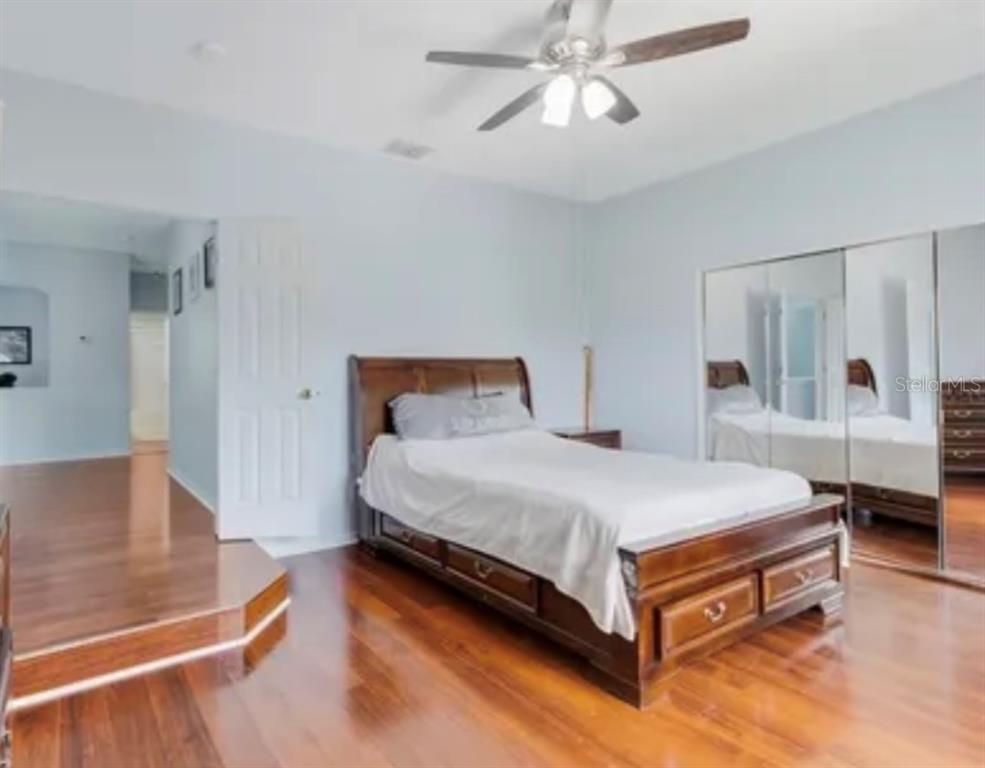 13315 Daffodil Way Astatula, FL 34705 - Photo 17 of 29 a spacious bedroom with a bed and a chandelier