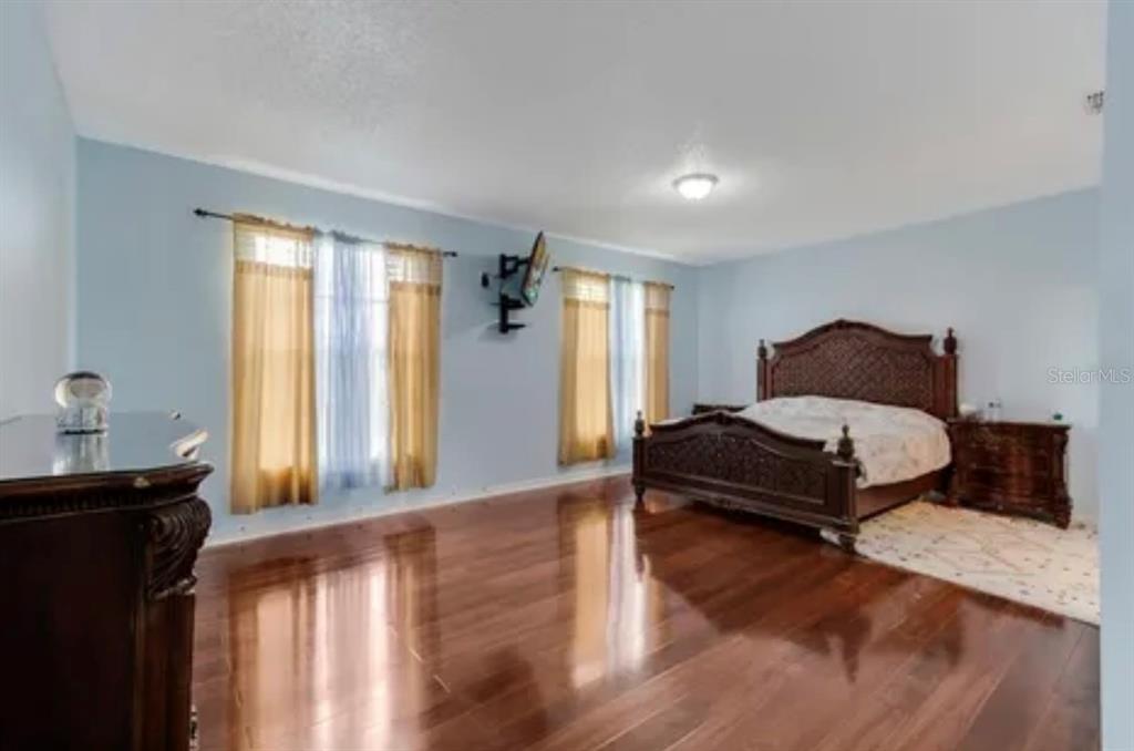 13315 Daffodil Way Astatula, FL 34705 - Photo 20 of 29 a bedroom with a bed and wooden floor