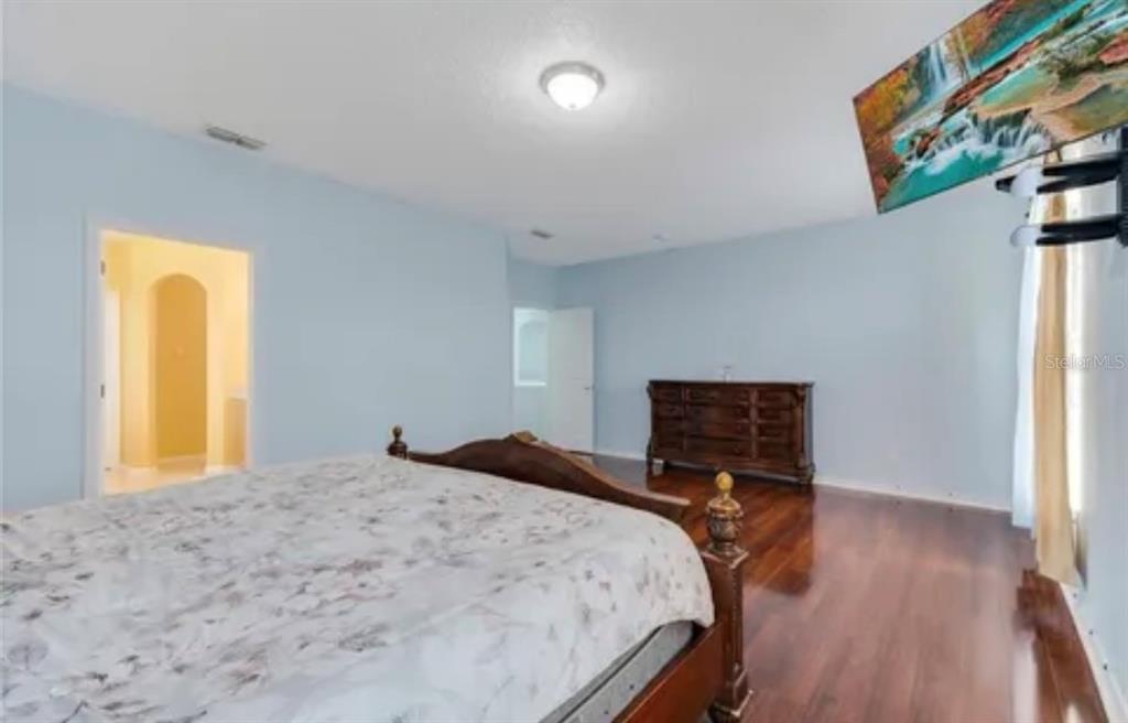 13315 Daffodil Way Astatula, FL 34705 - Photo 21 of 29 a bedroom with a bed and wooden floor