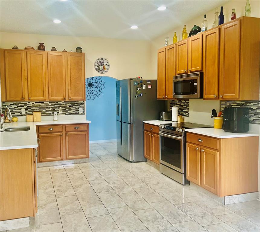13315 Daffodil Way Astatula, FL 34705 - Photo 9 of 29 a kitchen with stainless steel appliances a stove cabinets and a refrigerator