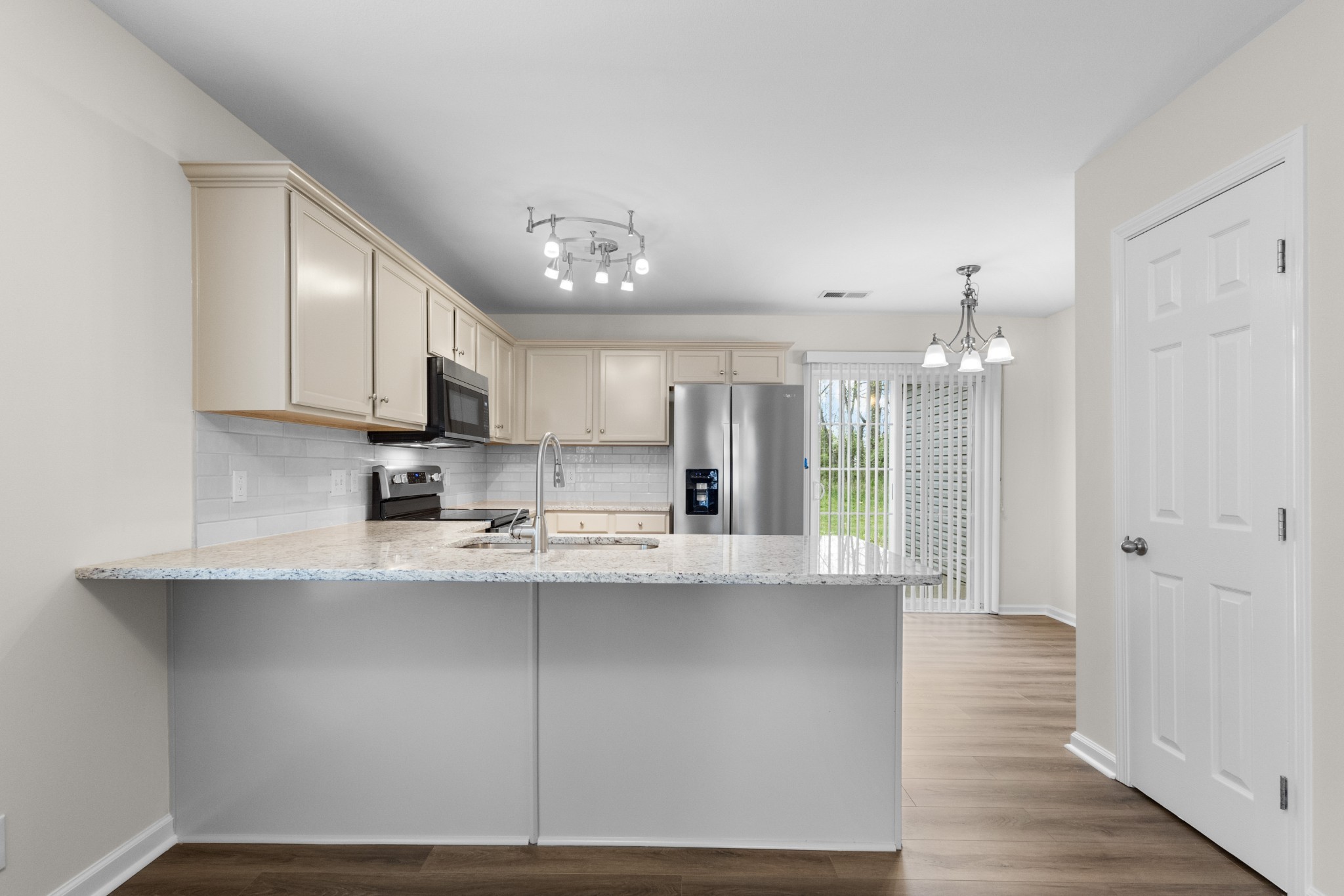 179 Alexander Boulevard Clarksville, TN 37040 - Photo 14 of 40 a large kitchen with stainless steel appliances granite countertop a stove a sink and white cabinets with wooden floor