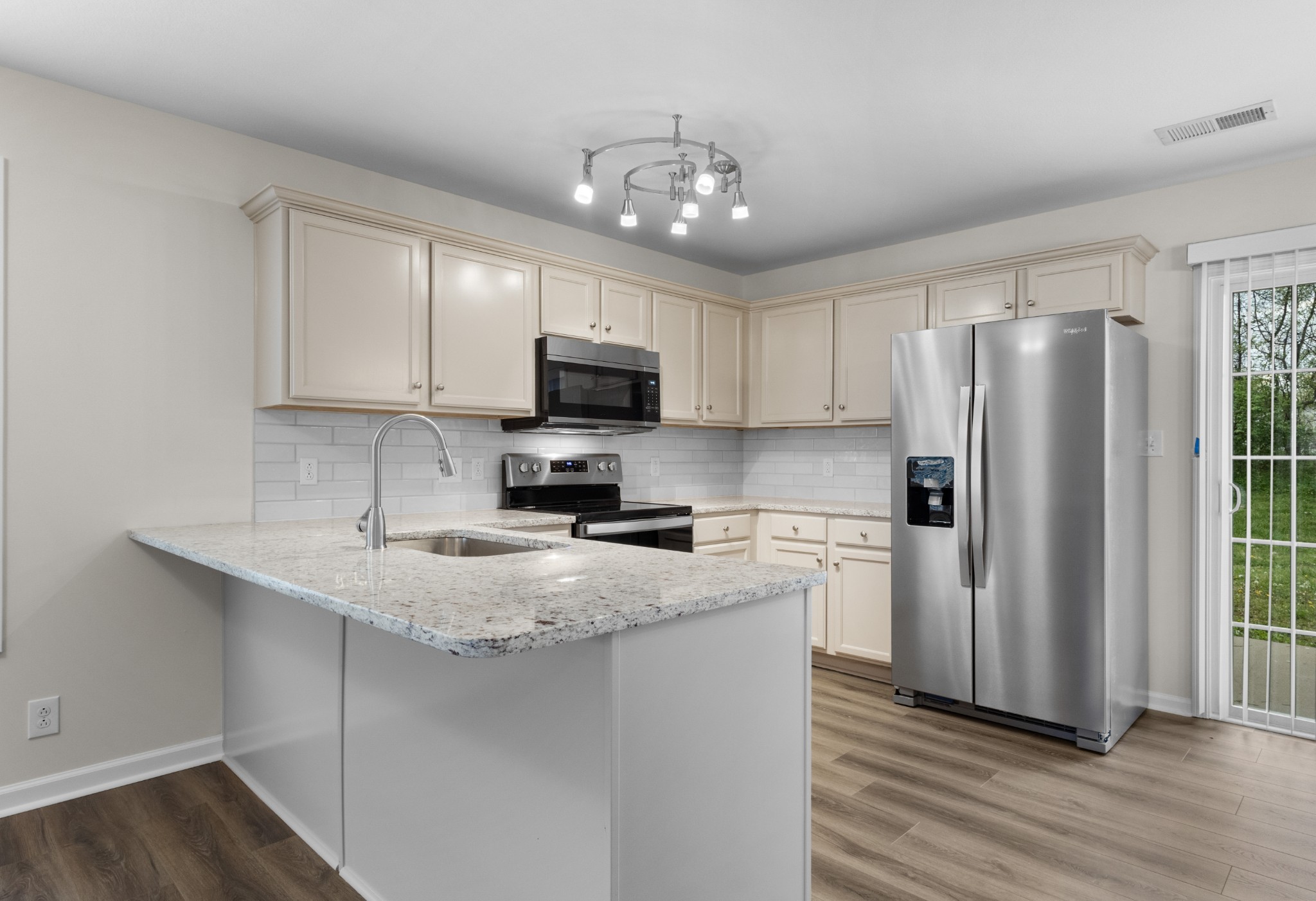 179 Alexander Boulevard Clarksville, TN 37040 - Photo 16 of 40 a kitchen with kitchen island granite countertop a refrigerator stove and microwave