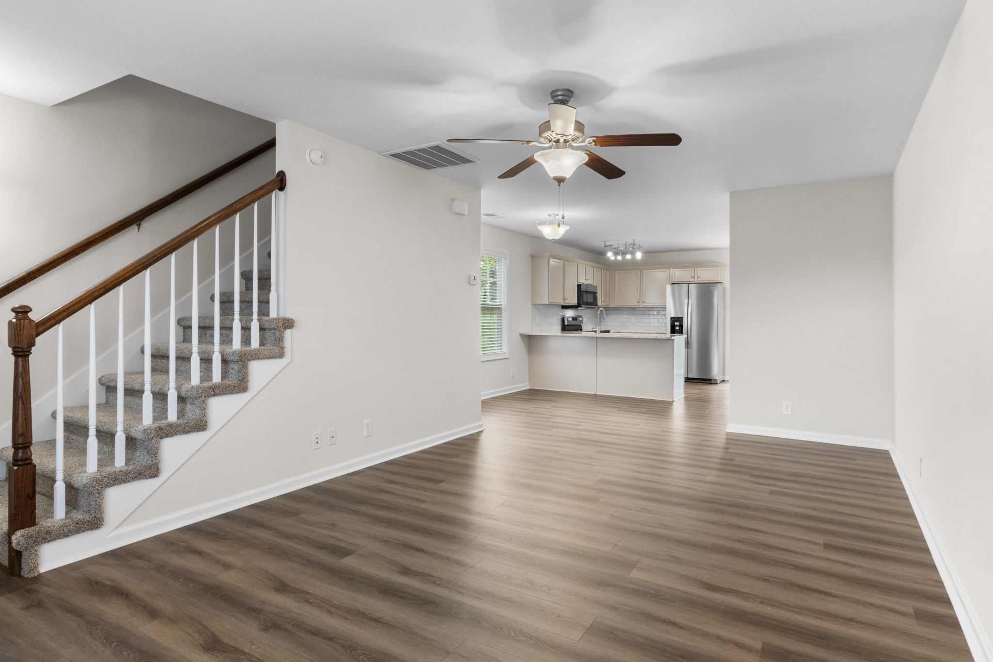 179 Alexander Boulevard Clarksville, TN 37040 - Photo 8 of 40 a view of an empty room and kitchen with wooden floor and fan