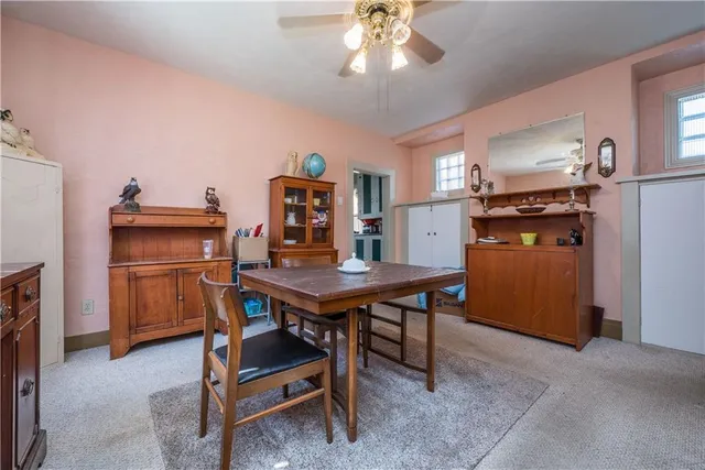 a room with a table chairs and refrigerator