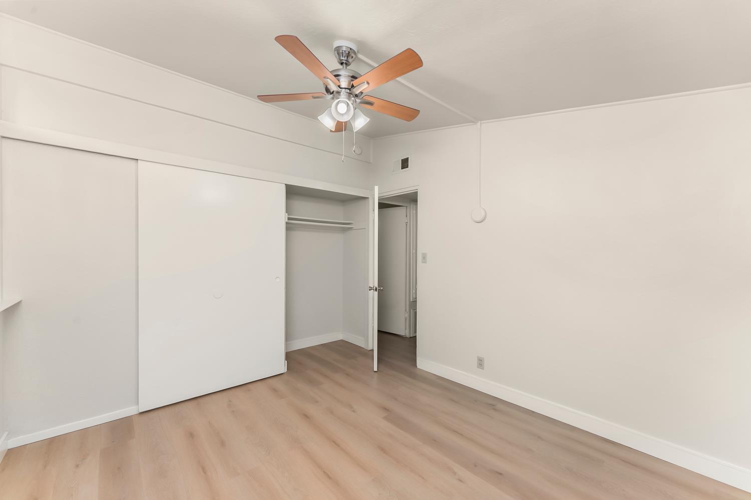 317 Brookwood Road Roseville, CA 95678 - Photo 22 of 36 an empty room with a ceiling fan and wooden floor