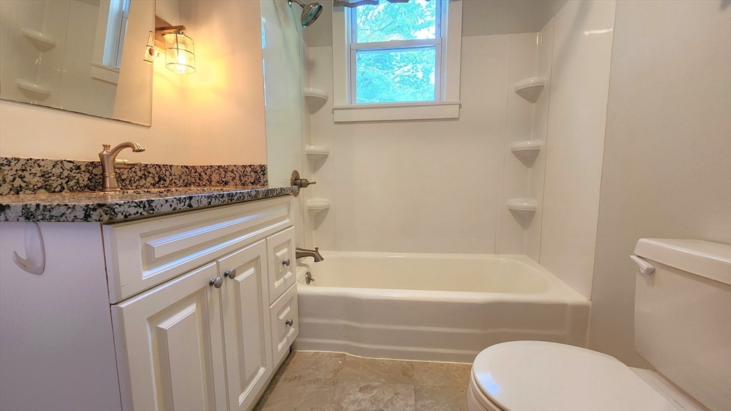 8 Fay Street, Unit 2 Westborough, MA 01581 - Photo 10 of 15 a bathroom with a granite countertop bathtub shower sink vanity and toilet