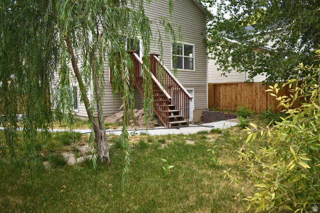 3327 East Windhover Road Eagle Mountain, UT 84005 - Photo 37 of 38 Rear exterior of the property featuring horizontal siding and a two-story wooden deck with stairs