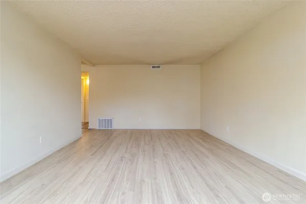 a view of an empty room and wooden floor