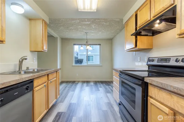 a kitchen with granite countertop wooden floors and stainless steel appliances