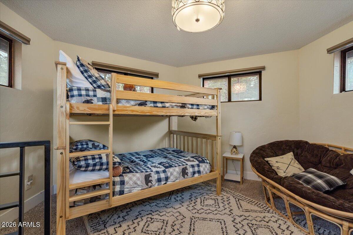 5979 Dearing Road Prescott, AZ 86305 - Photo 40 of 48 a bedroom with a bed and a chandelier