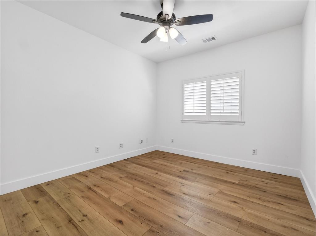 4345 Timberglen Road Dallas, TX 75287 - Photo 19 of 26 an empty room with wooden floor fan and windows