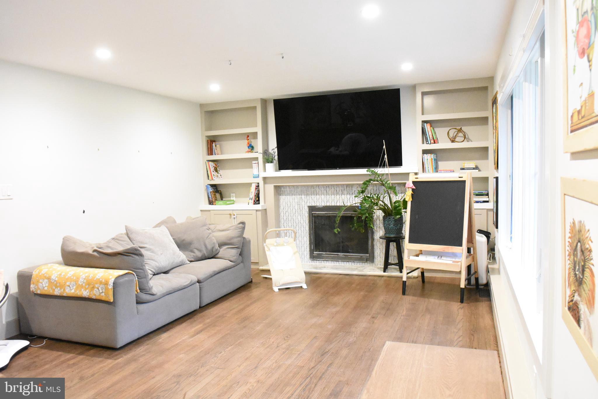 28 Delaware Avenue Ewing, NJ 08628 - Photo 38 of 46 a living room with furniture a flat screen tv and a fireplace