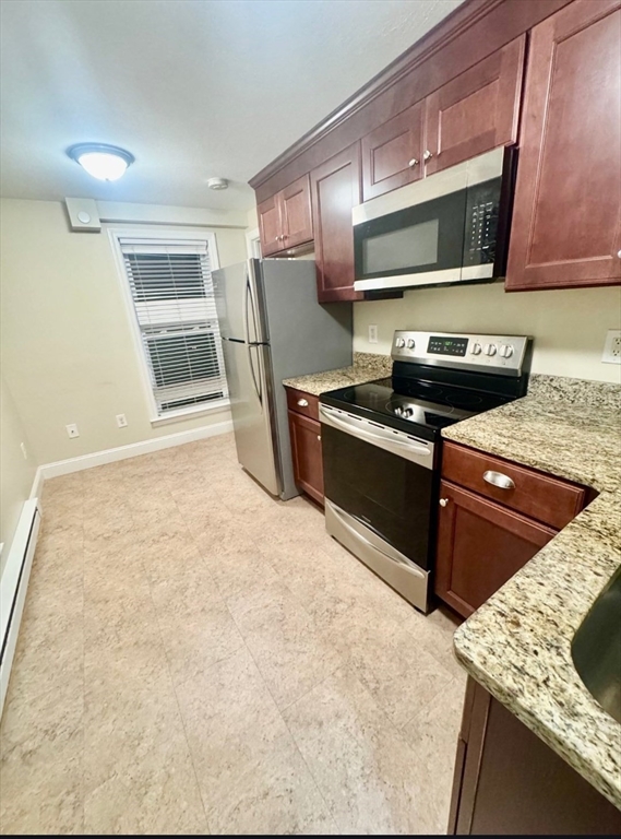 75 Bowers Street, Unit 4 Lowell, MA 01854 - Photo 2 of 5 a kitchen with stainless steel appliances granite countertop a sink stove and microwave