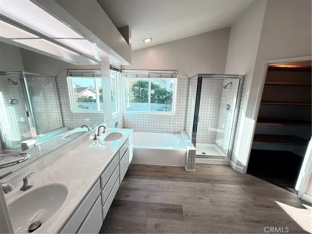 a spacious bathroom with a double vanity sink a mirror and a shower