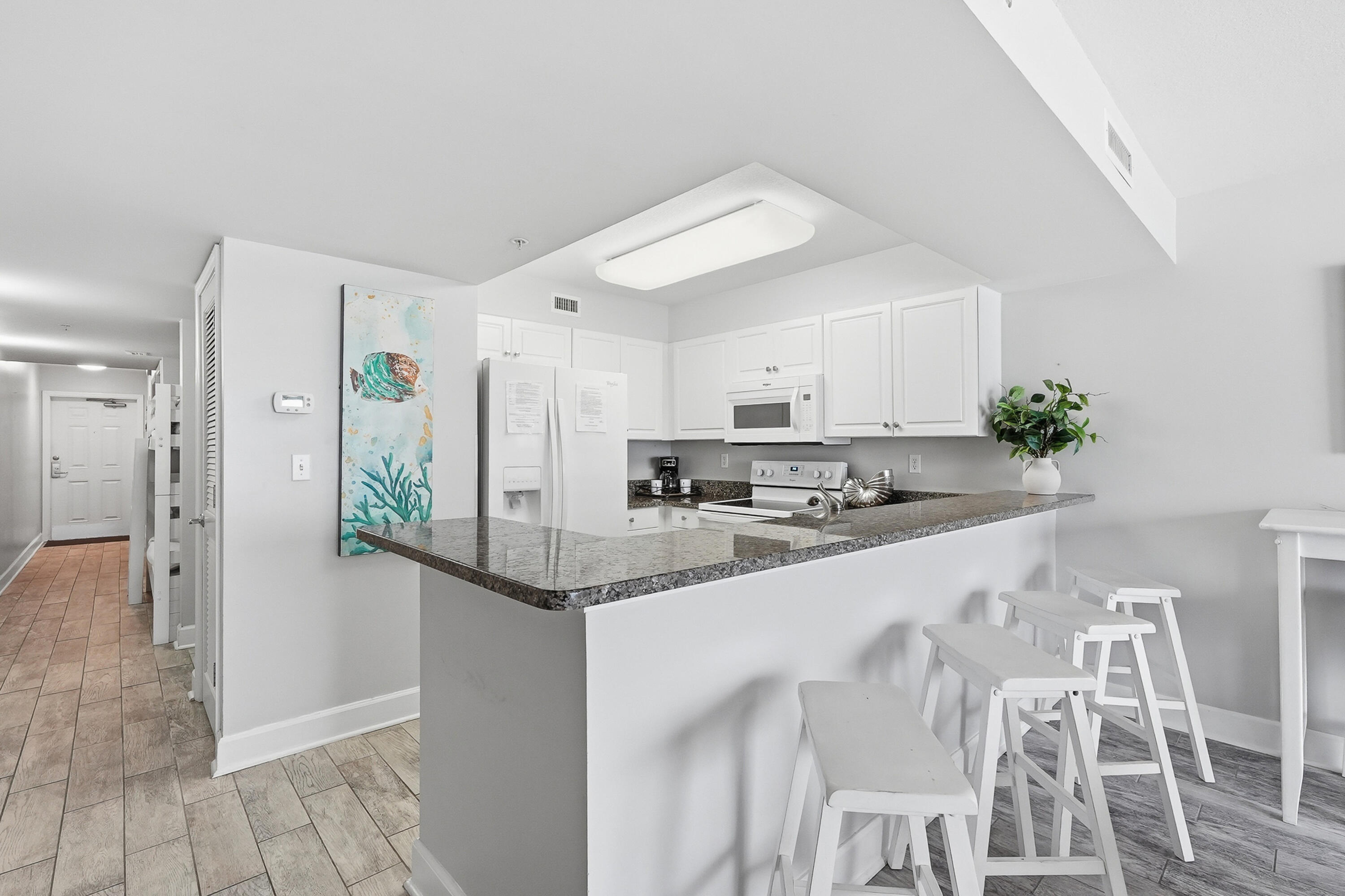 866 Santa Rosa Boulevard, Unit 506 Fort Walton Beach, FL 32548 - Photo 8 of 49 a kitchen with stainless steel appliances kitchen island granite countertop a refrigerator and a sink