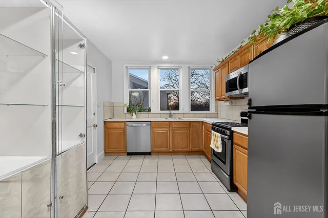 a large white kitchen with a stove a sink dishwasher and a refrigerator