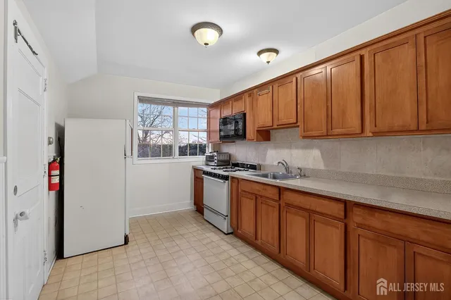 a kitchen with stainless steel appliances granite countertop a refrigerator sink and stove