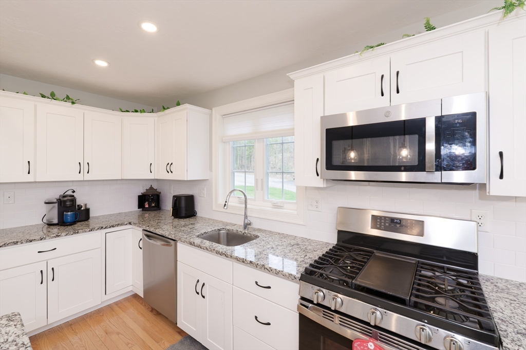 1202 Hazelwood Way, Unit 1202 Clinton, MA 01510 - Photo 11 of 38 a kitchen with stainless steel appliances a sink a stove and microwave