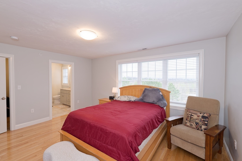 1202 Hazelwood Way, Unit 1202 Clinton, MA 01510 - Photo 18 of 38 a bedroom with a bed and wooden floor