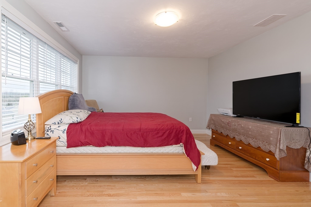1202 Hazelwood Way, Unit 1202 Clinton, MA 01510 - Photo 19 of 38 a bedroom with a bed and a flat screen tv