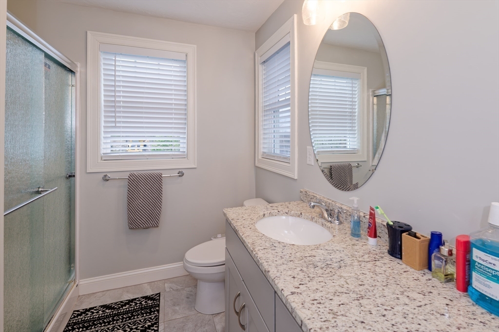 1202 Hazelwood Way, Unit 1202 Clinton, MA 01510 - Photo 23 of 38 a bathroom with a granite countertop sink a toilet and a mirror