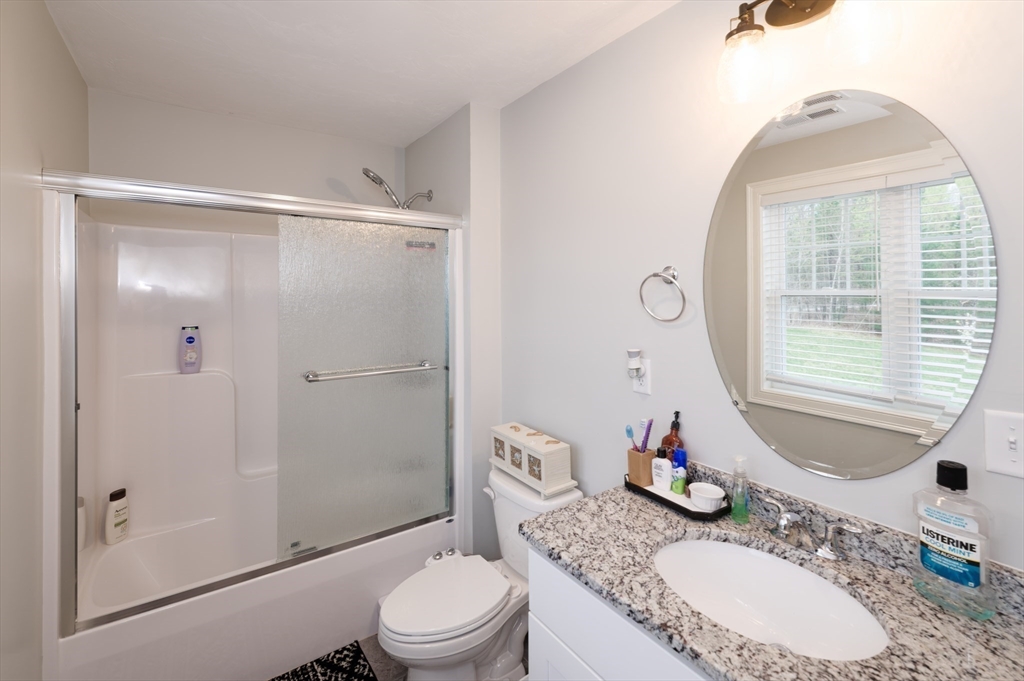 1202 Hazelwood Way, Unit 1202 Clinton, MA 01510 - Photo 27 of 38 a bathroom with a granite countertop sink toilet and shower