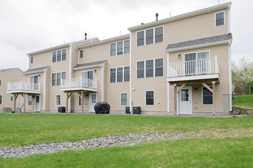 1202 Hazelwood Way, Unit 1202 Clinton, MA 01510 - Photo 37 of 38 a large building with a garden