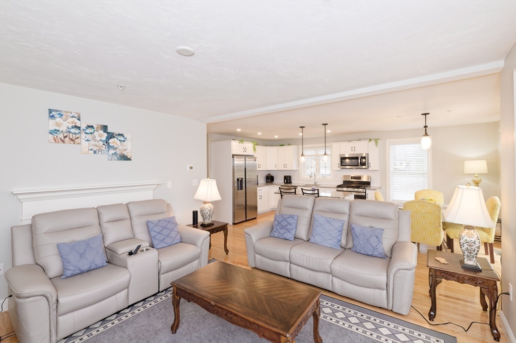 1202 Hazelwood Way, Unit 1202 Clinton, MA 01510 - Photo 6 of 38 a living room with furniture white walls and a view of kitchen