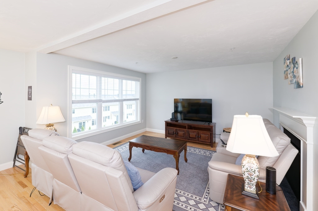1202 Hazelwood Way, Unit 1202 Clinton, MA 01510 - Photo 7 of 38 a living room with furniture a flat screen tv and a window