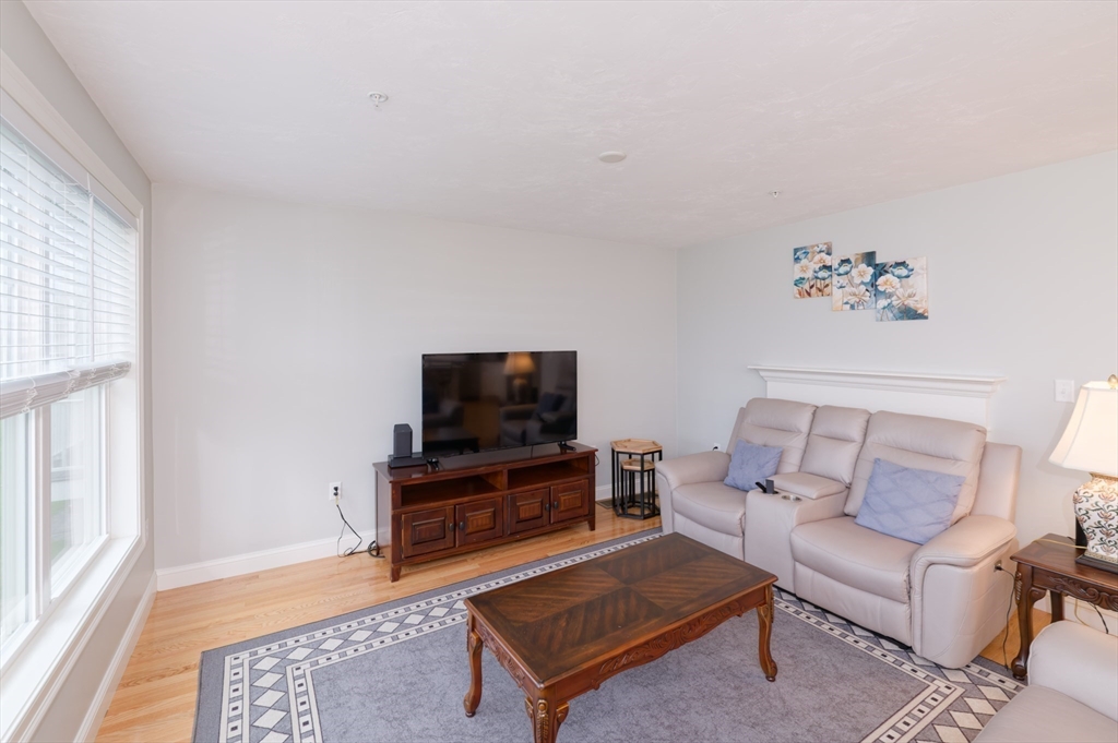 1202 Hazelwood Way, Unit 1202 Clinton, MA 01510 - Photo 8 of 38 a living room with furniture and a flat screen tv
