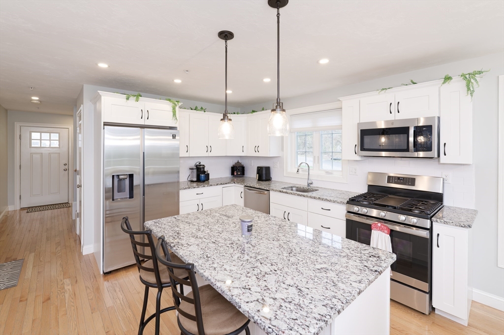 1202 Hazelwood Way, Unit 1202 Clinton, MA 01510 - Photo 10 of 38 a kitchen with stainless steel appliances granite countertop a stove refrigerator sink and microwave