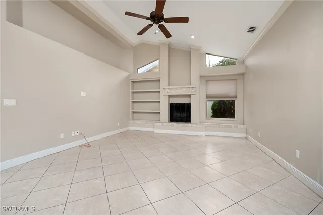 a view of an empty room with a fireplace and a window
