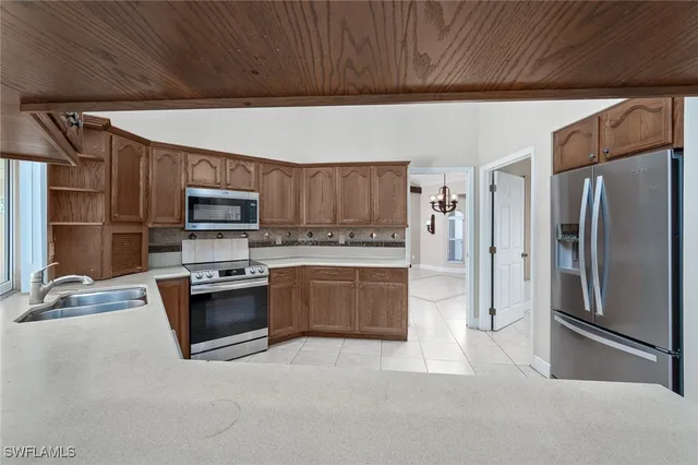 a kitchen with stainless steel appliances granite countertop a refrigerator stove and sink