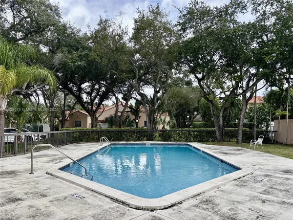 swimming pool view with trees in the background