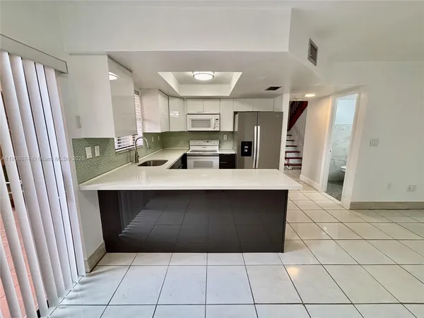 a kitchen with kitchen island cabinets and refrigerator